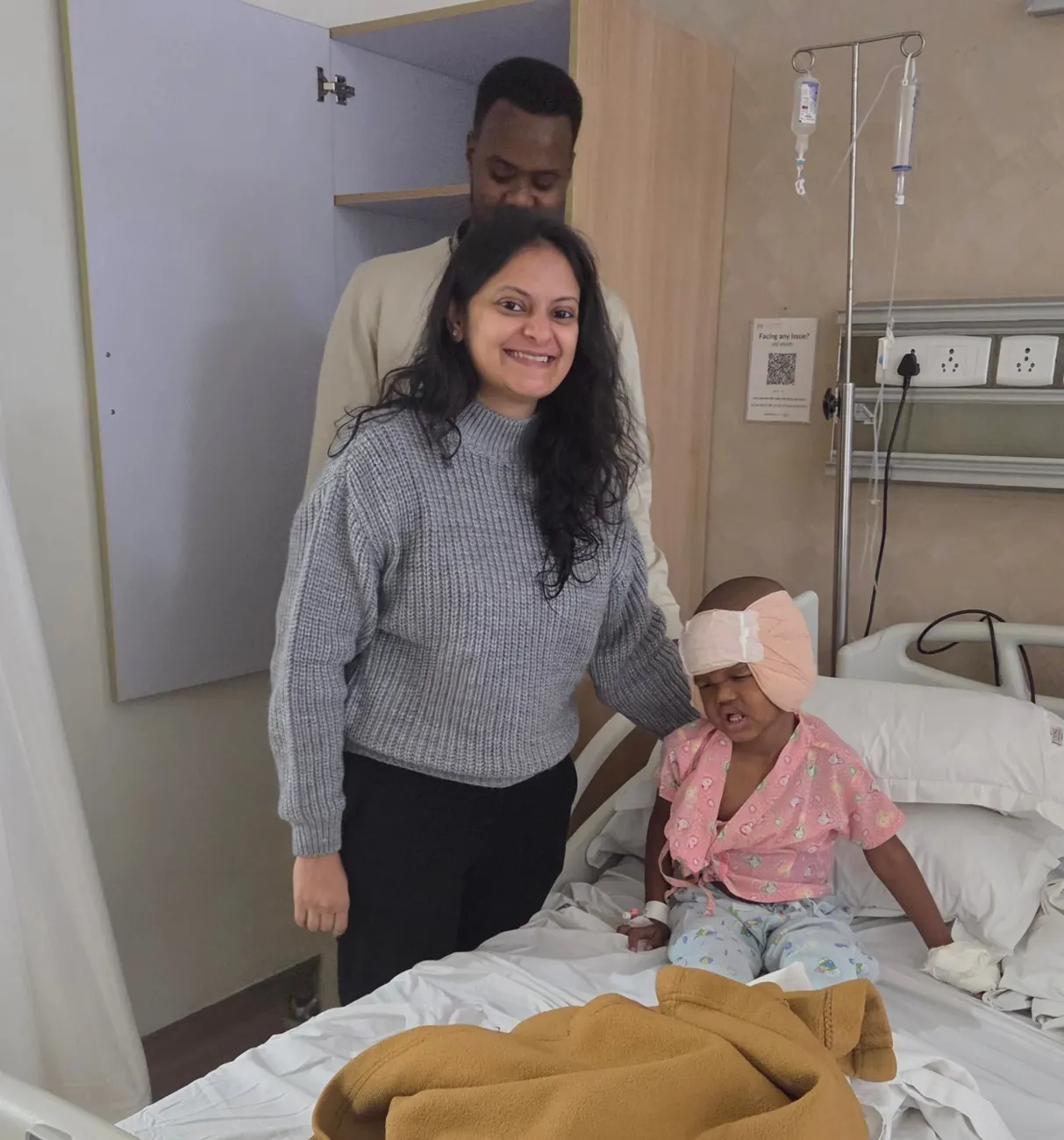 Dr. Trisha Srivastava with a young patient and his father on the ward
